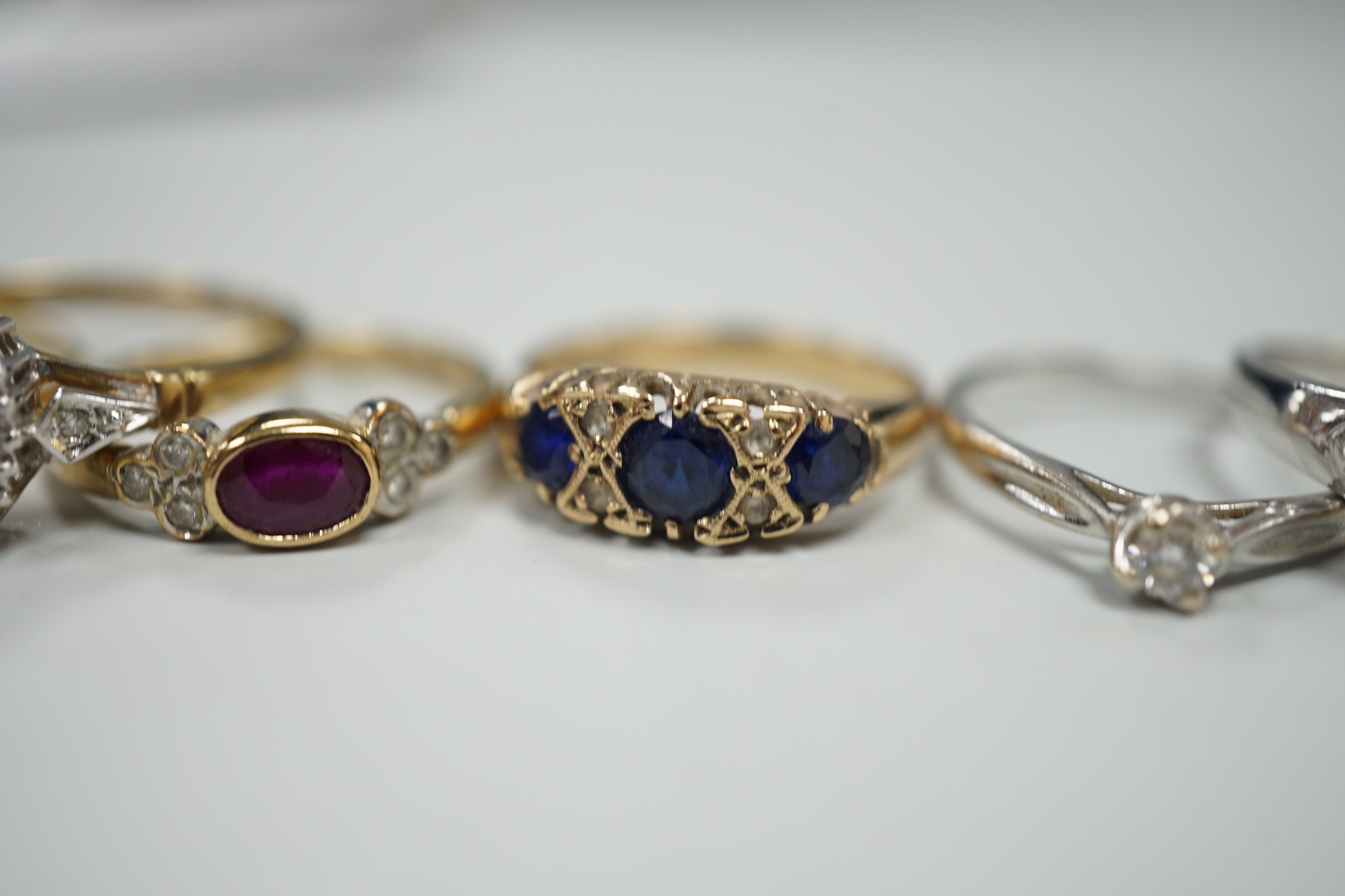 Seven assorted modern 9ct gold and gem set rings, including two solitaire diamond rings, together with a 9ct gold and amber set pendant, gross weight 19.3 grams.